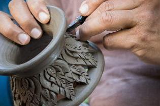 A person crafting a vase out of ceramics.